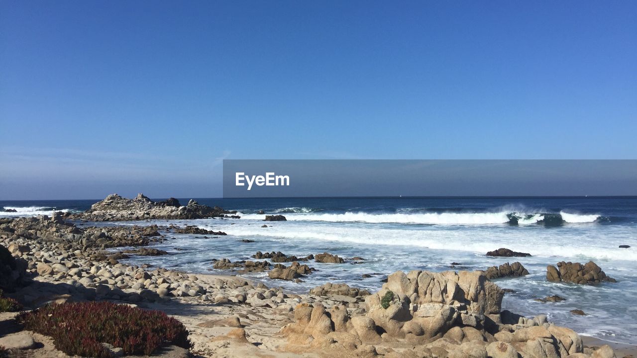 Scenic view of sea against clear blue sky