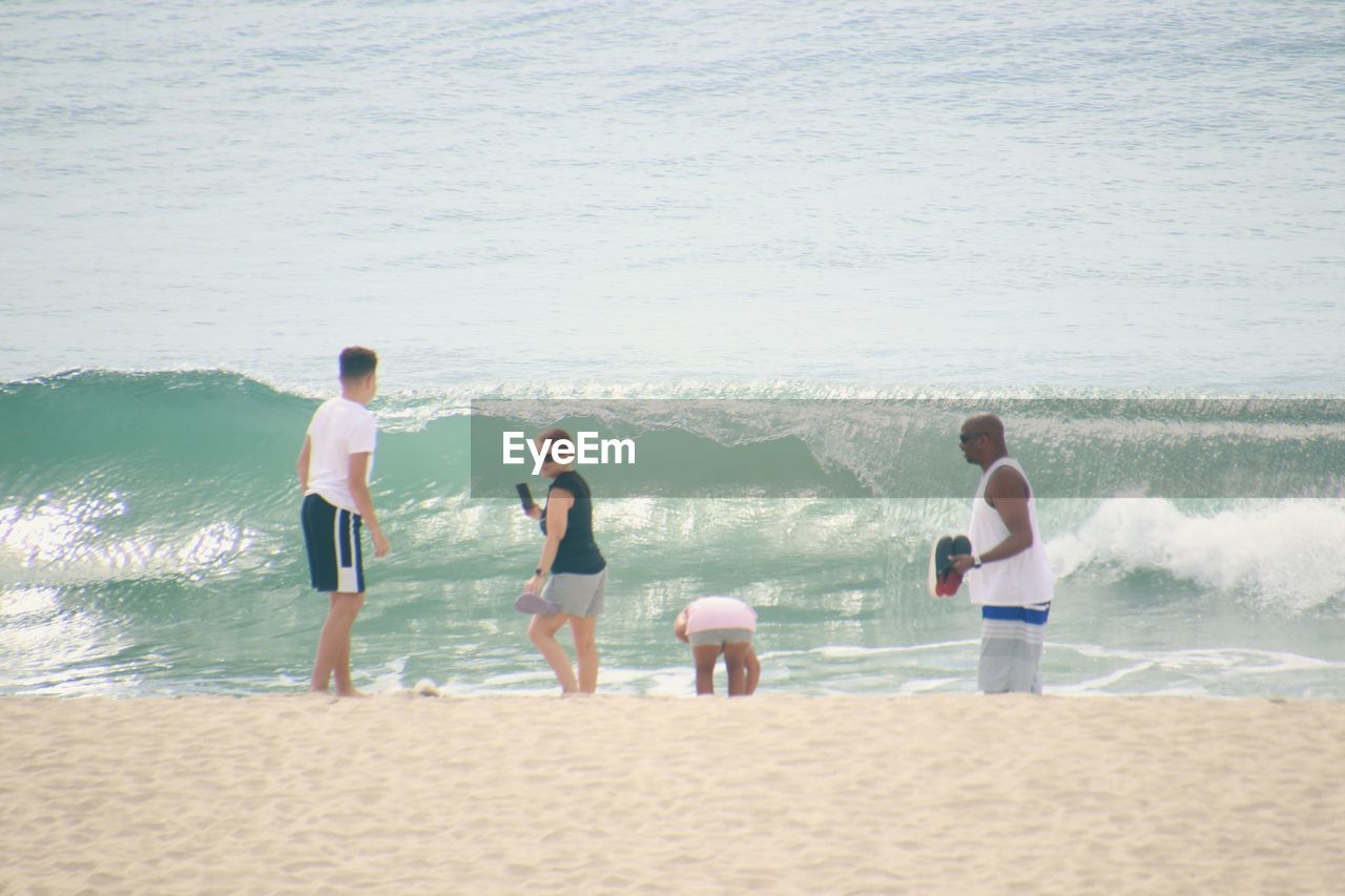 MEN STANDING ON BEACH