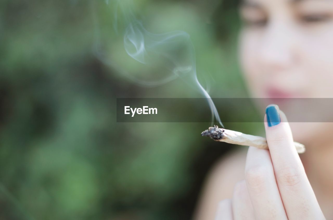 Close-up of woman smoking marijuana joint