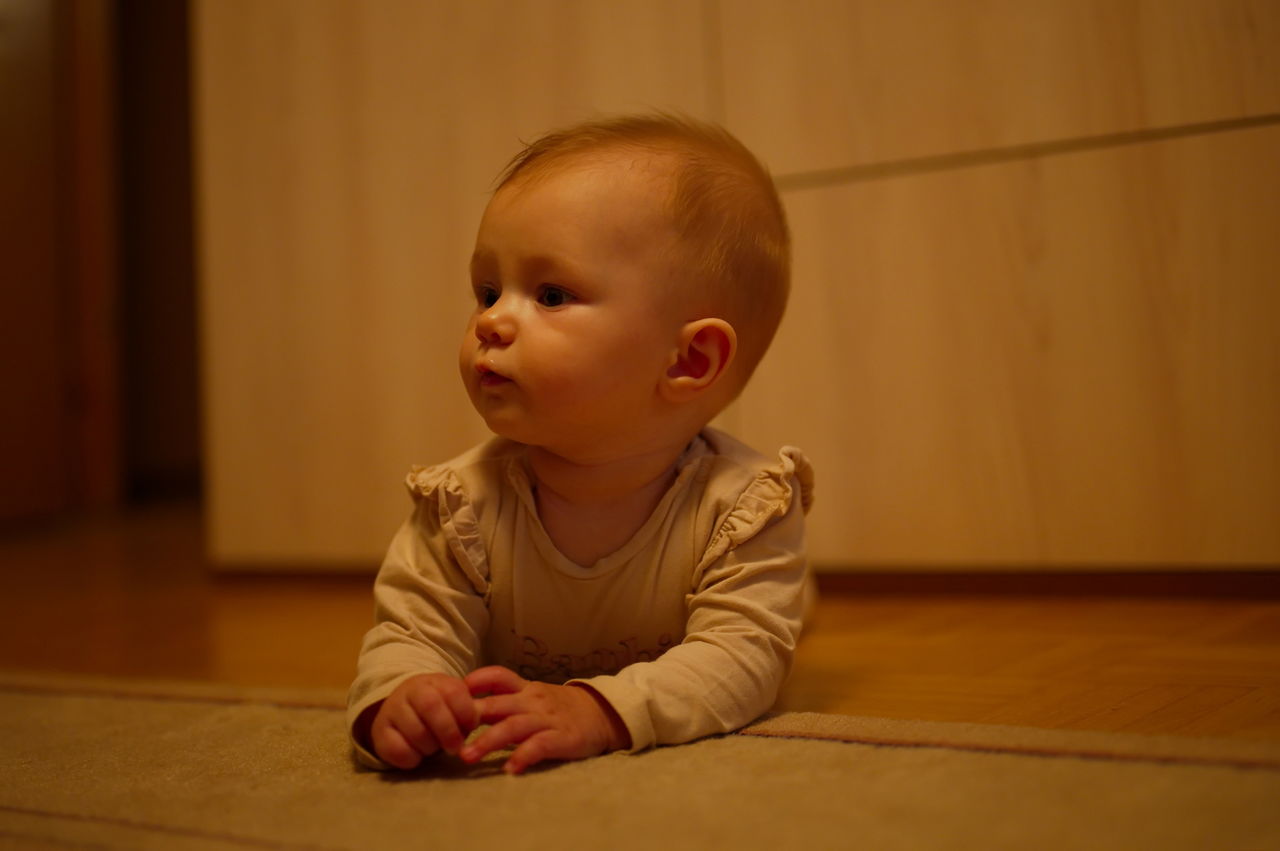 Little baby girl crawling on the floor at home