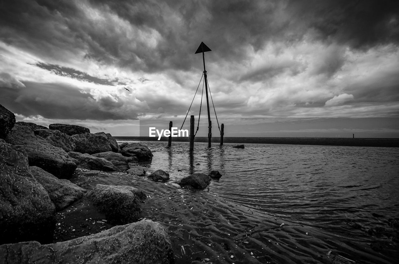 water, sky, cloud, sea, ocean, horizon, nature, scenics - nature, beauty in nature, black and white, beach, coast, land, wave, nautical vessel, tranquility, monochrome, monochrome photography, tranquil scene, shore, rock, sailboat, no people, darkness, environment, transportation, outdoors, horizon over water, dusk, seascape, dramatic sky, reflection, idyllic, non-urban scene, day