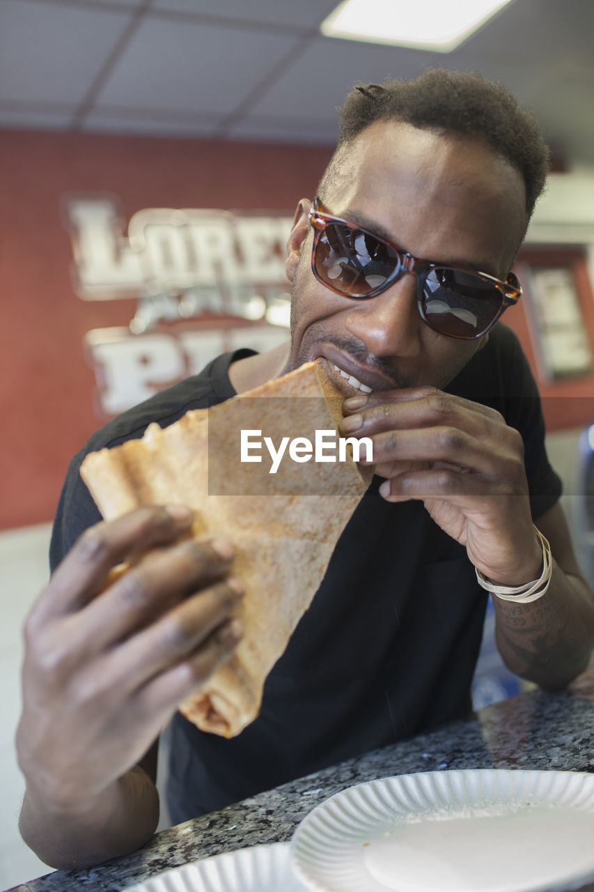 A young man eating pizza.