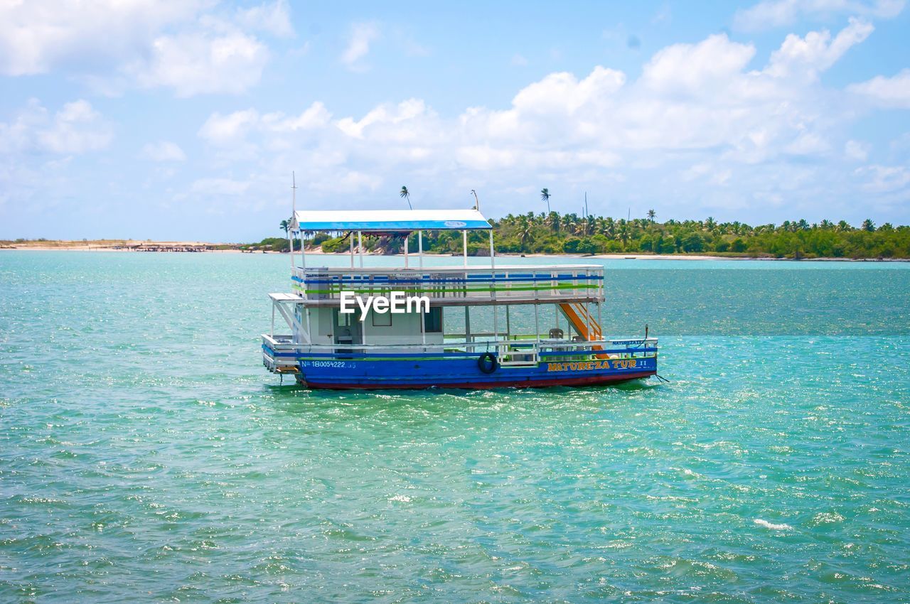 BOAT IN SEA AGAINST SKY