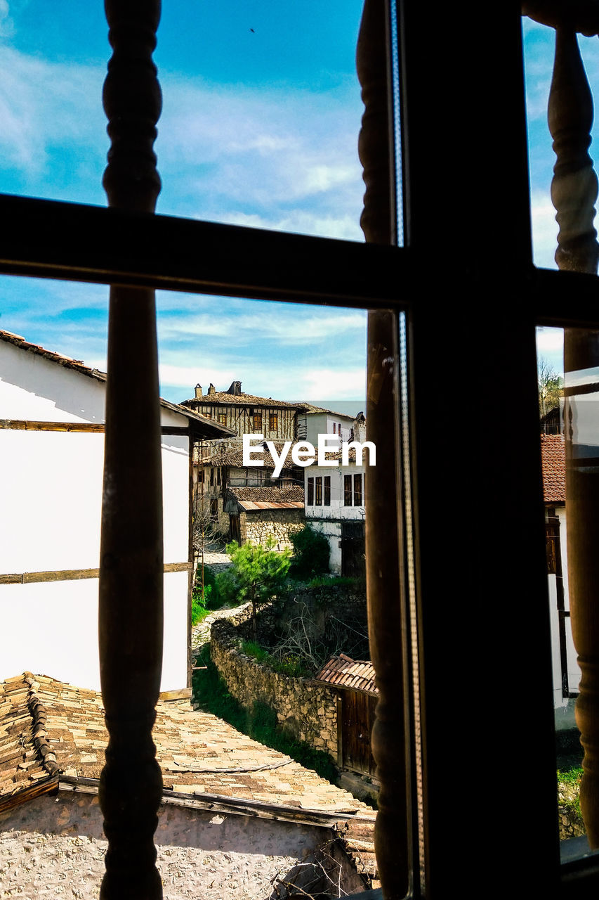 BUILDINGS SEEN THROUGH GLASS WINDOW