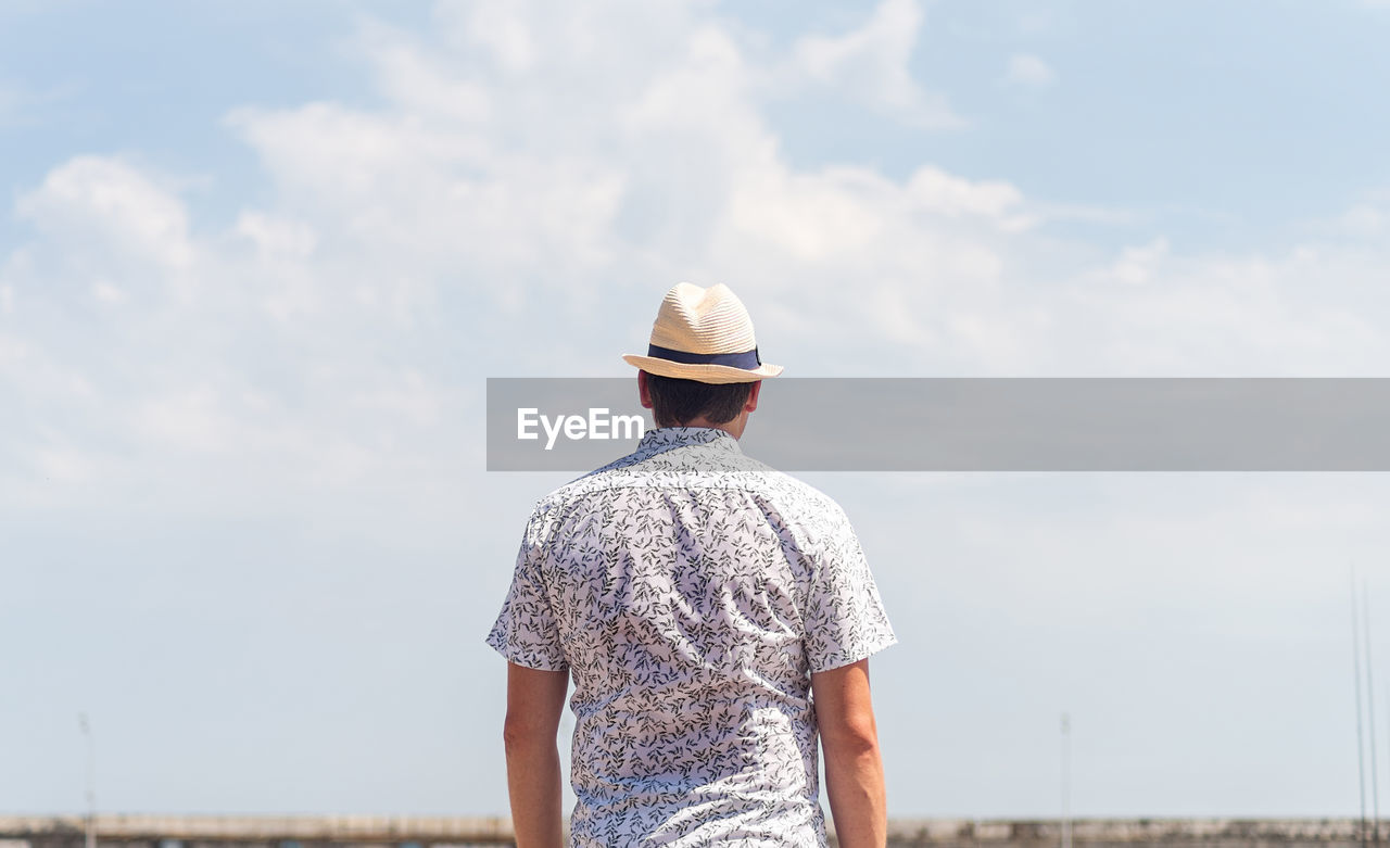 Rear view of man standing against sky