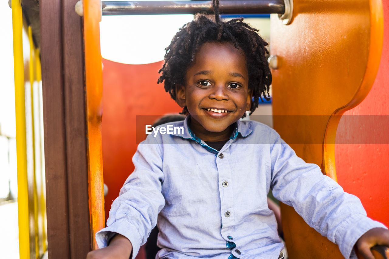 Portrait of smiling boy sitting outdoors