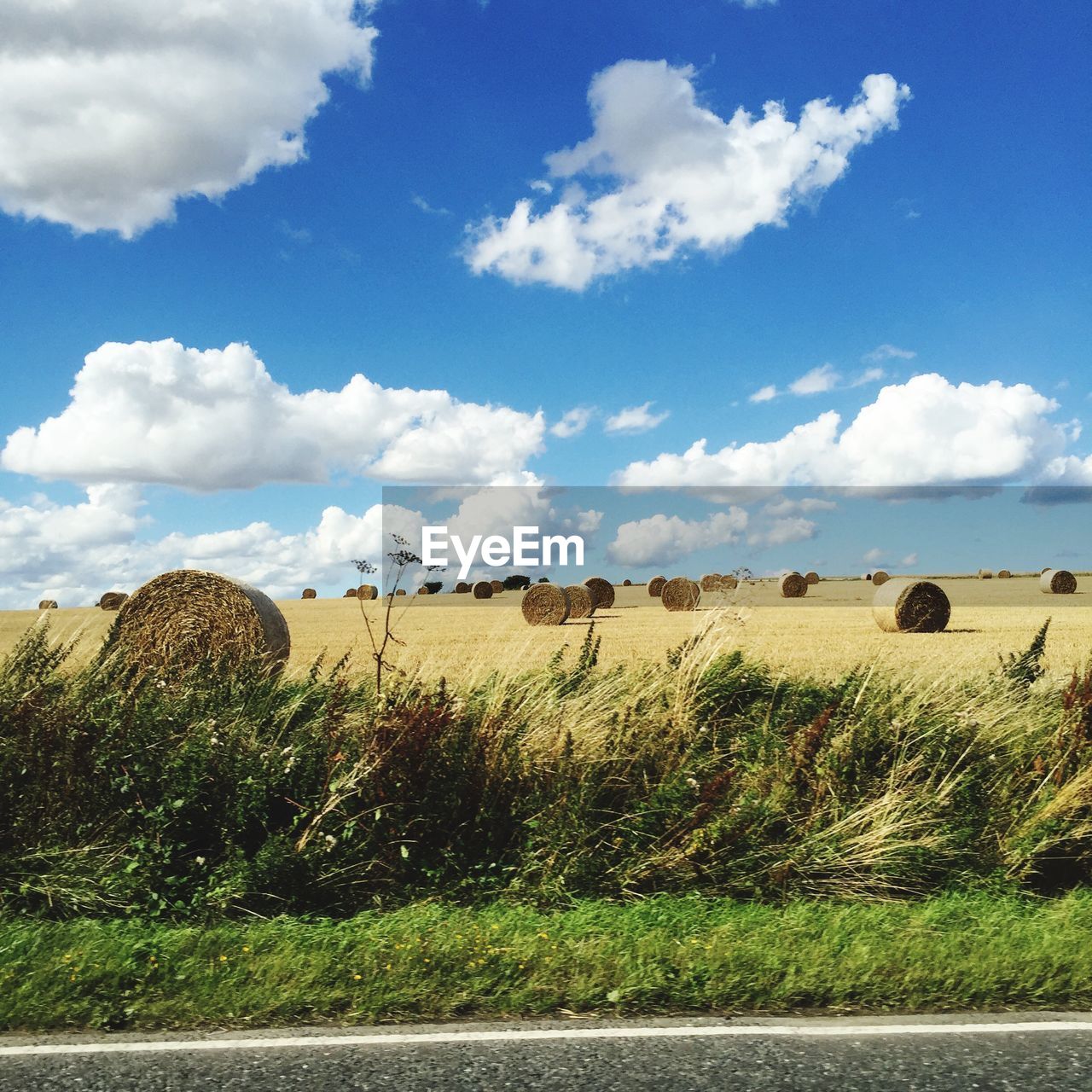 Hay bales on field against sky