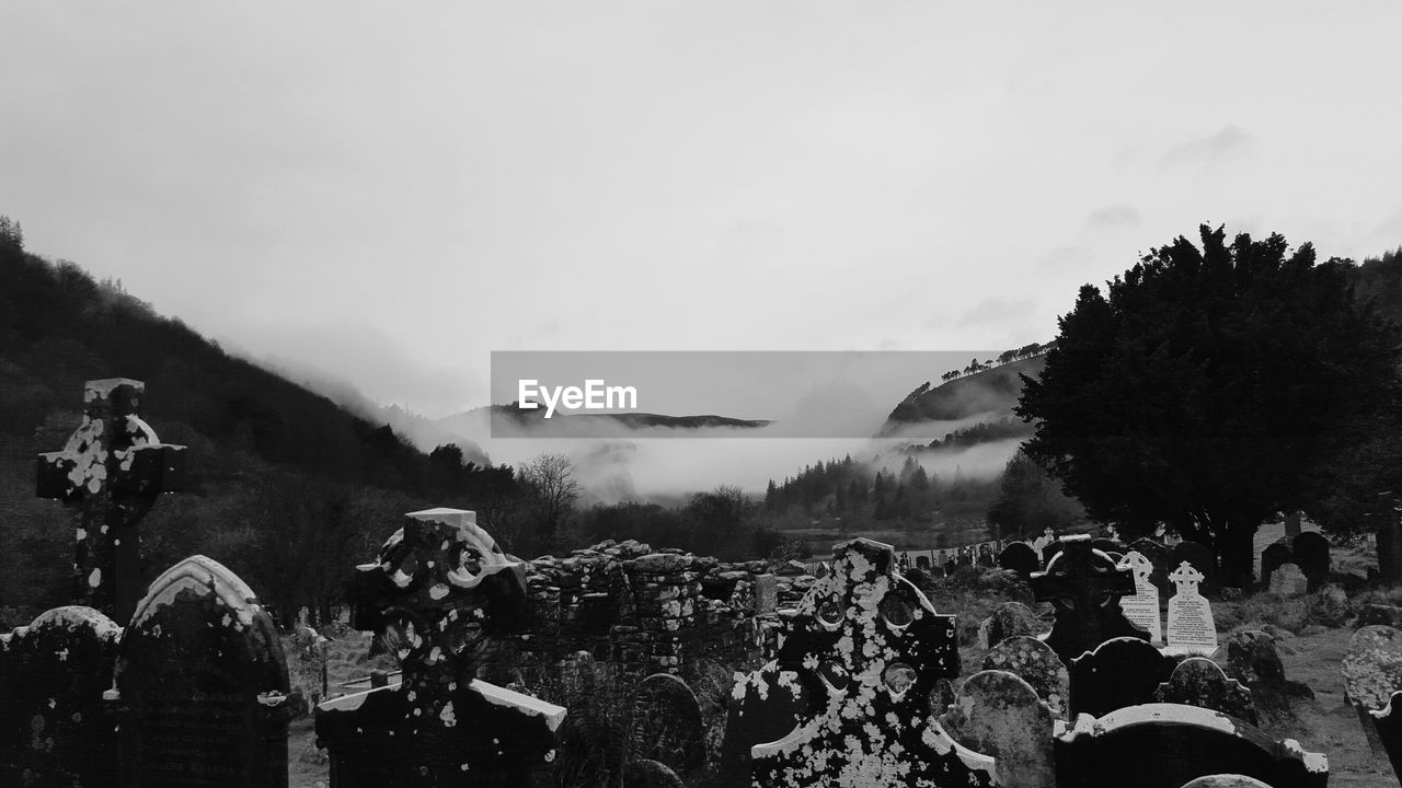 CROWD OF PEOPLE IN MOUNTAINS AGAINST SKY