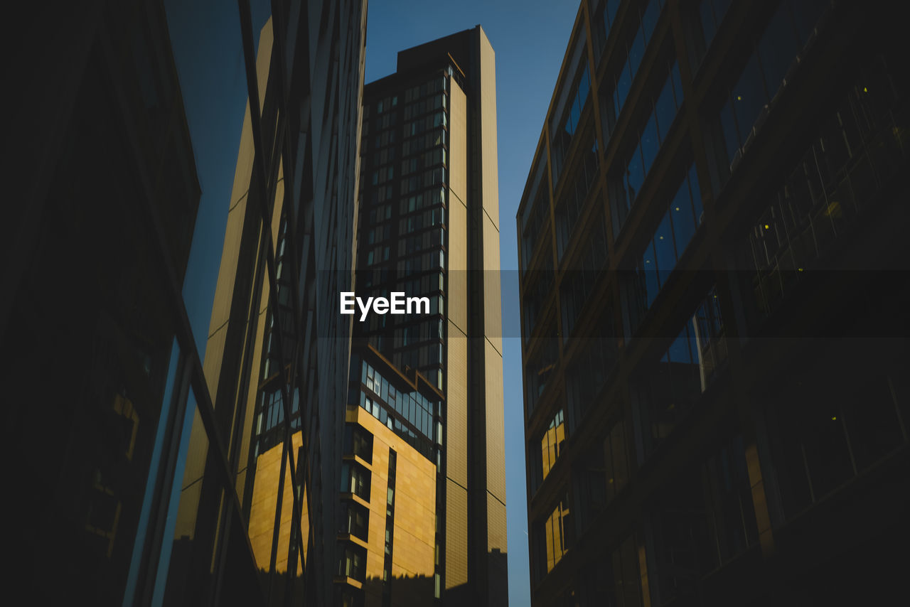 Low angle view of buildings against clear sky at night