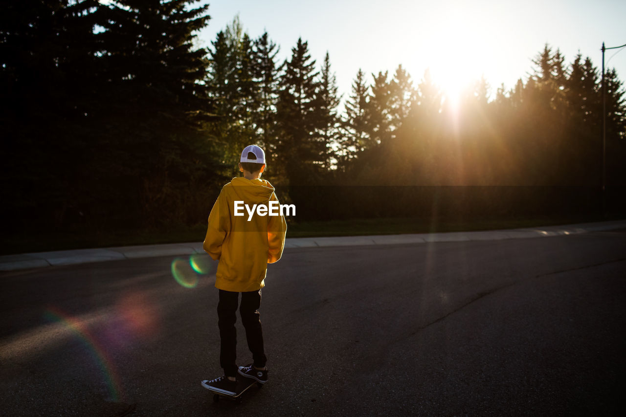 Teen boy skateboarding on street