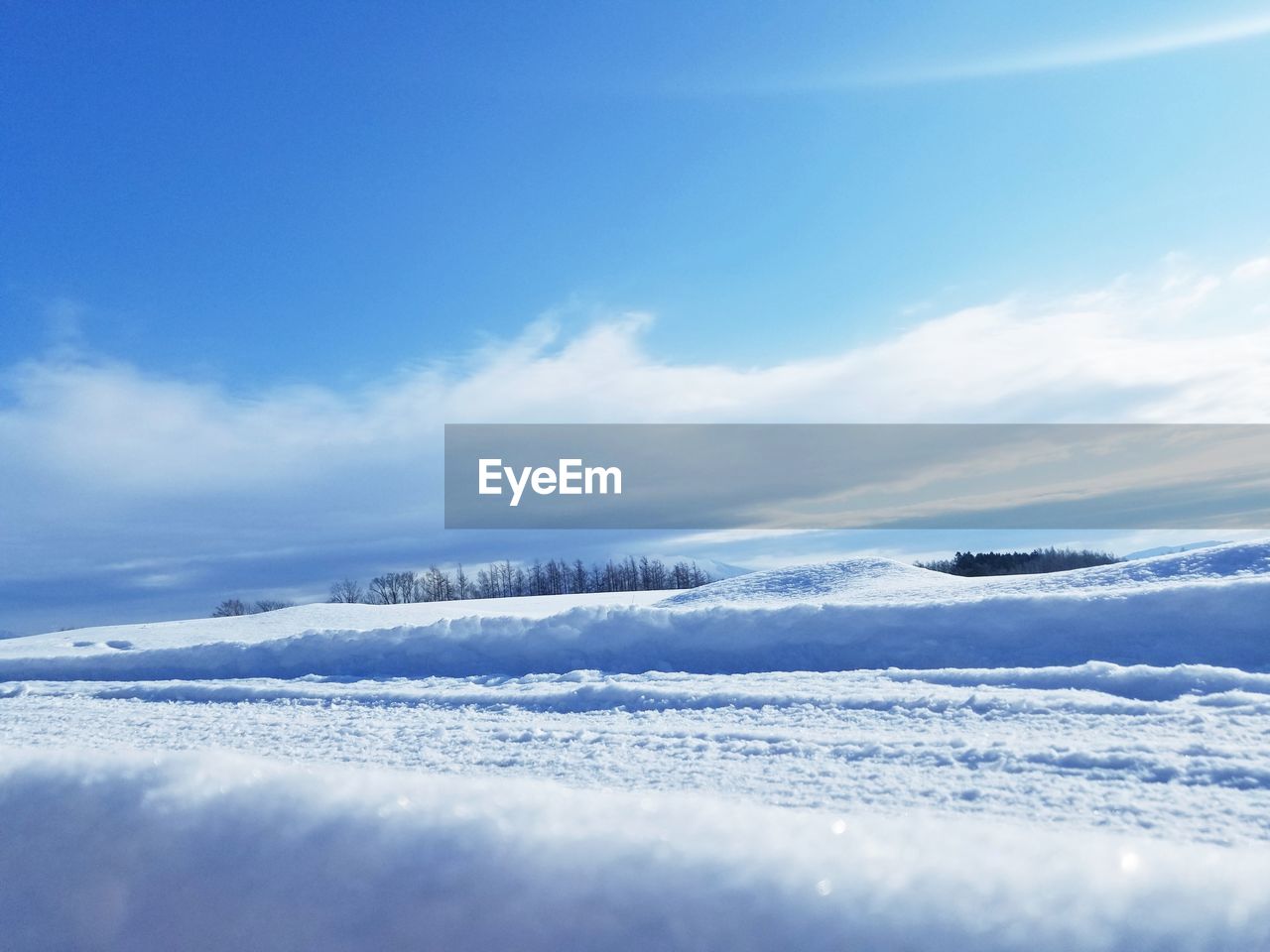 SCENIC VIEW OF SNOW COVERED LANDSCAPE AGAINST BLUE SKY