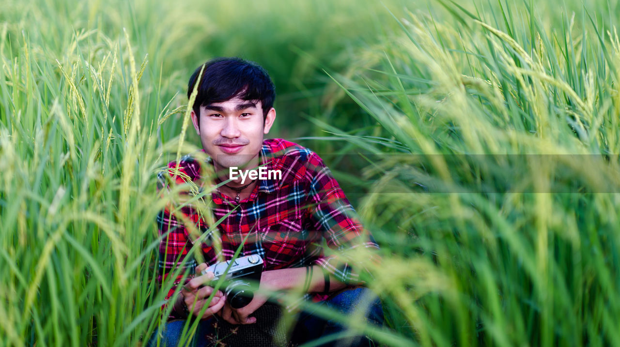 PORTRAIT OF HANDSOME YOUNG MAN ON FIELD