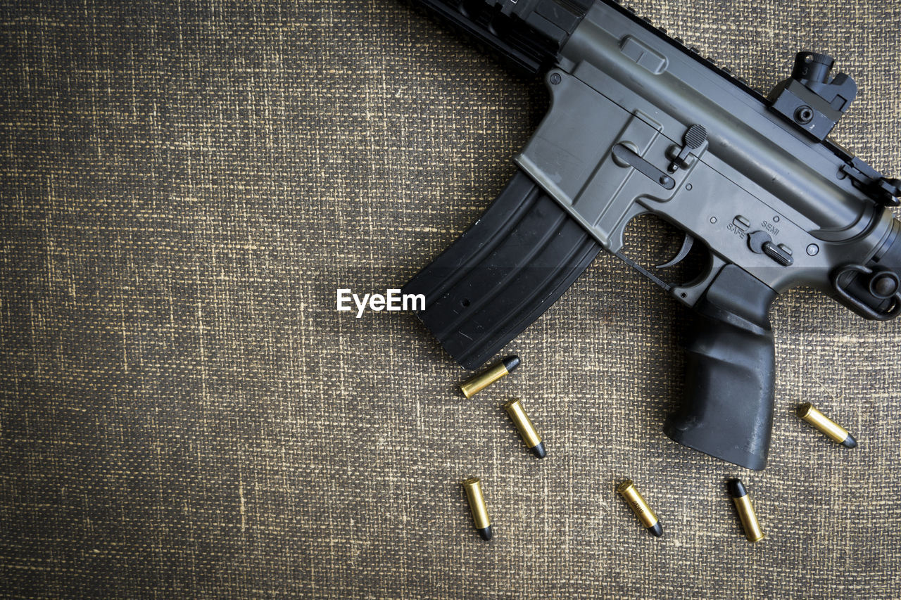 Directly above shot of gun and bullets on table