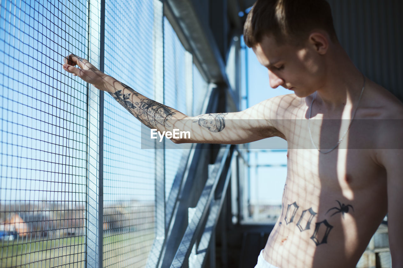 Young man standing by window