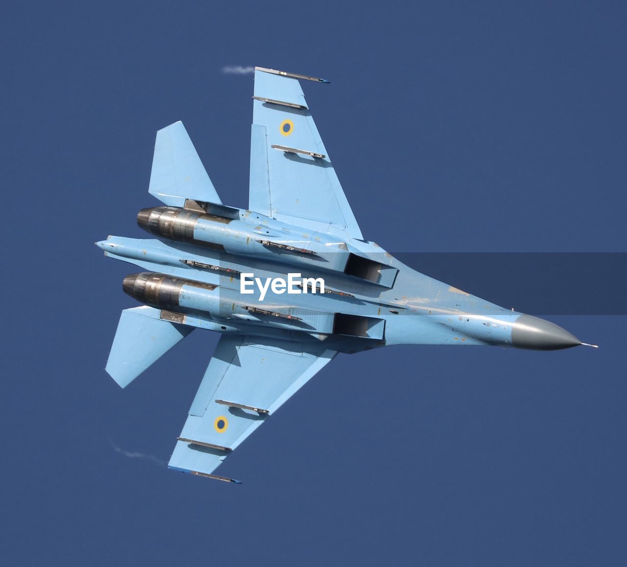 Low angle view of airplane flying against clear blue sky