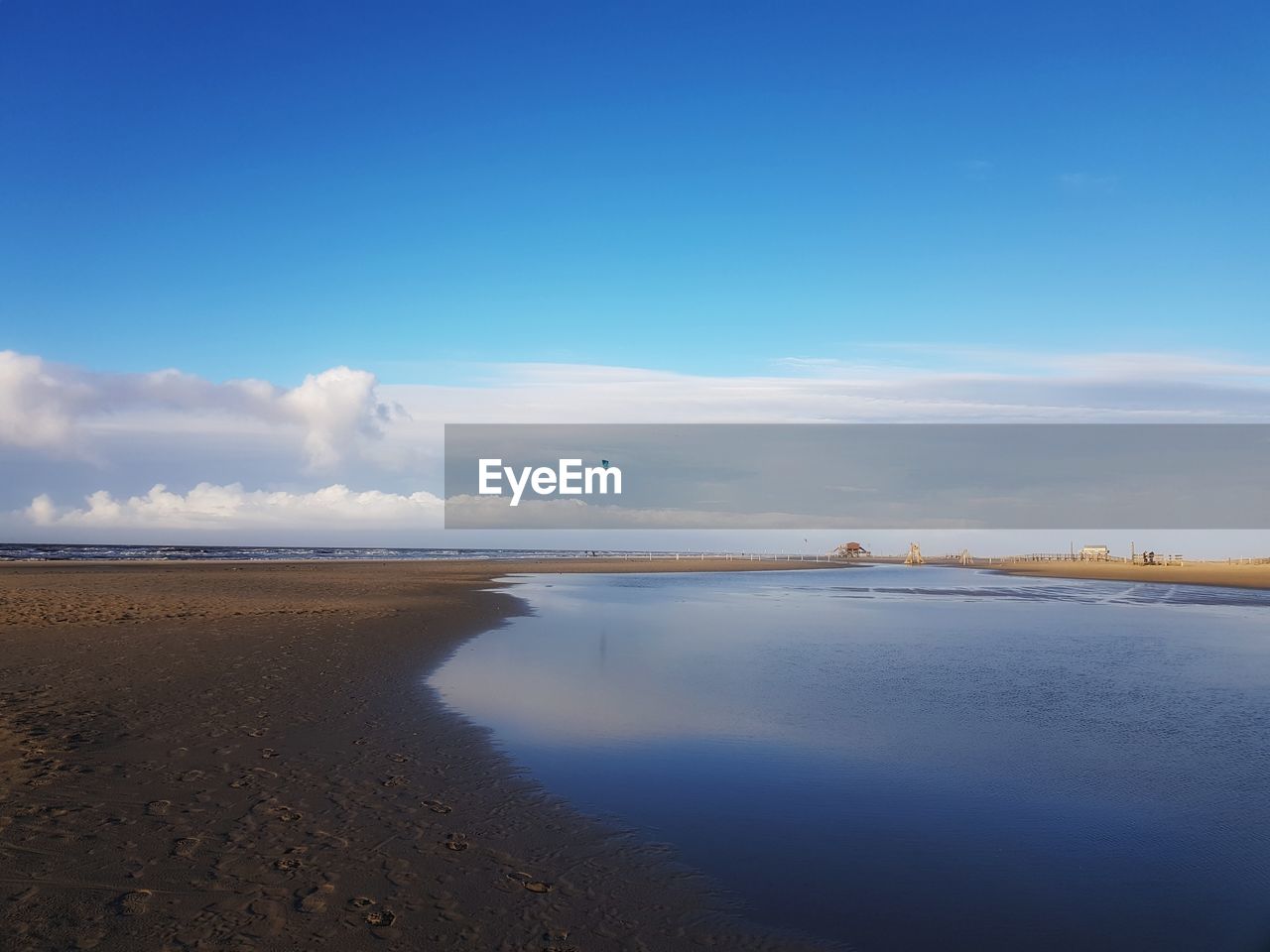 Scenic view of beach against blue sky