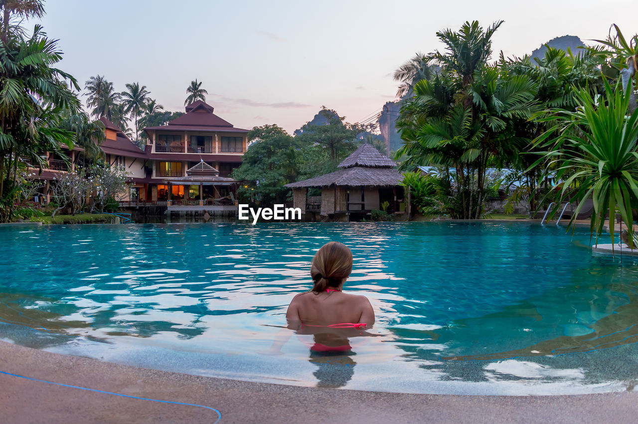 REAR VIEW OF GIRL IN SWIMMING POOL