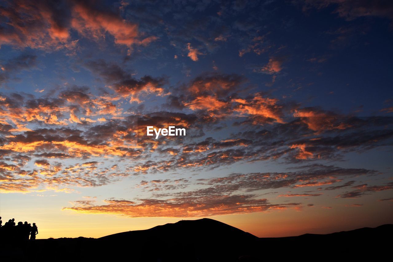 Low angle view of dramatic sky over silhouette landscape