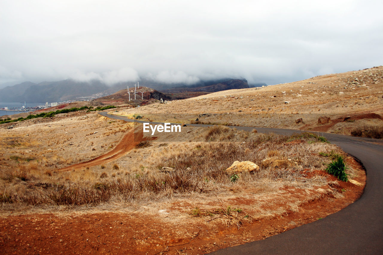 Empty road, terra ground and windmills. madeira, portugal. eco renewable energy sources trend