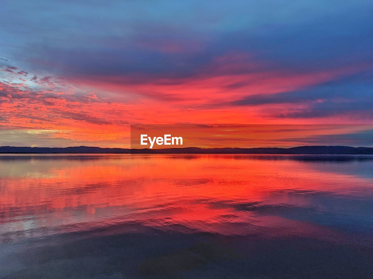 SCENIC VIEW OF LAKE AGAINST ORANGE SKY