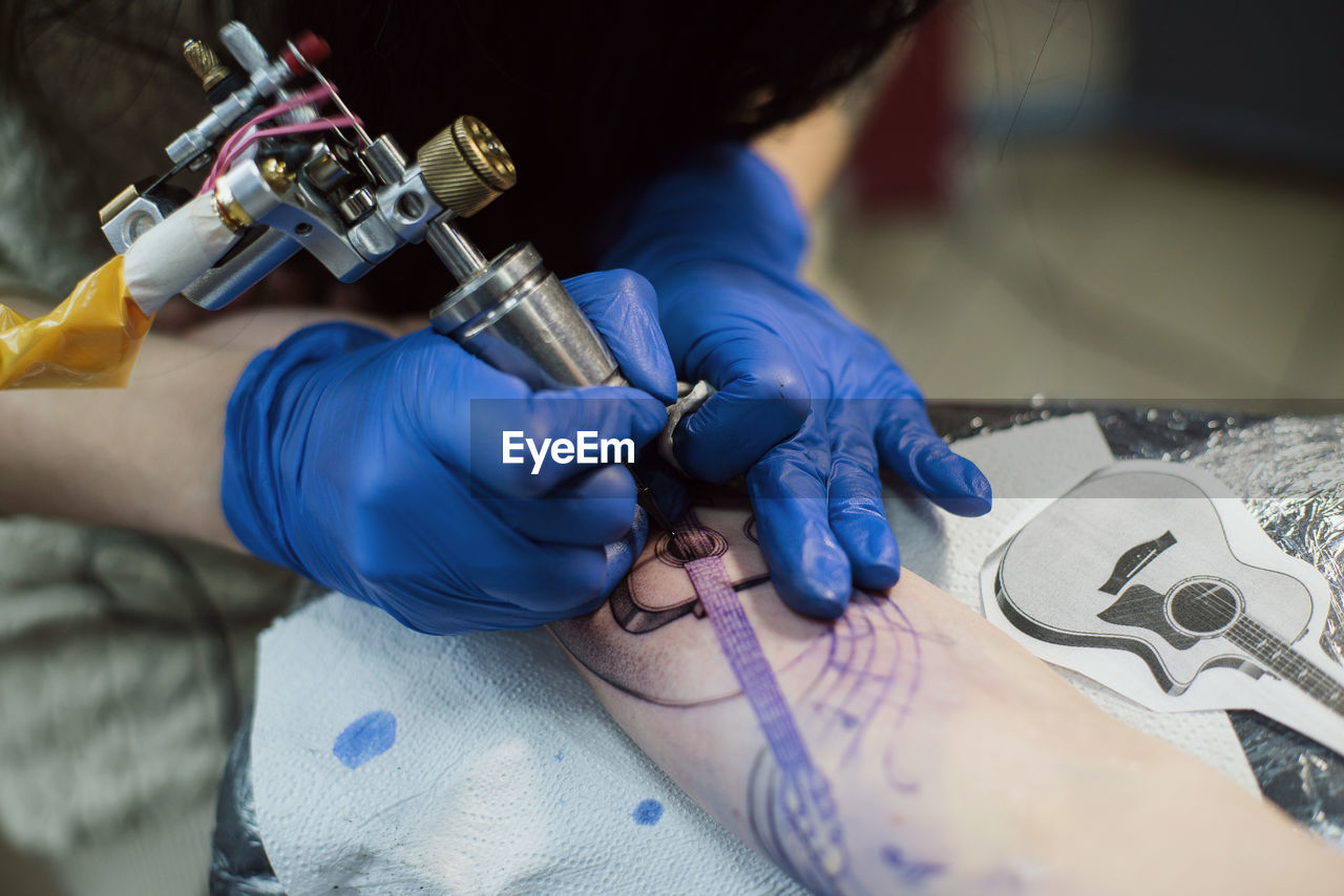 MIDSECTION OF MAN WORKING WITH TATTOO