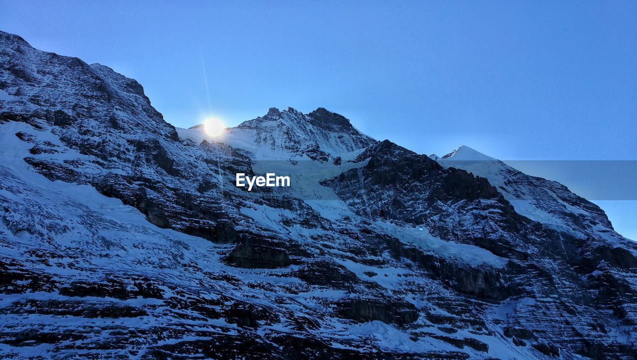 Scenic view of snowcapped mountains against blue sky