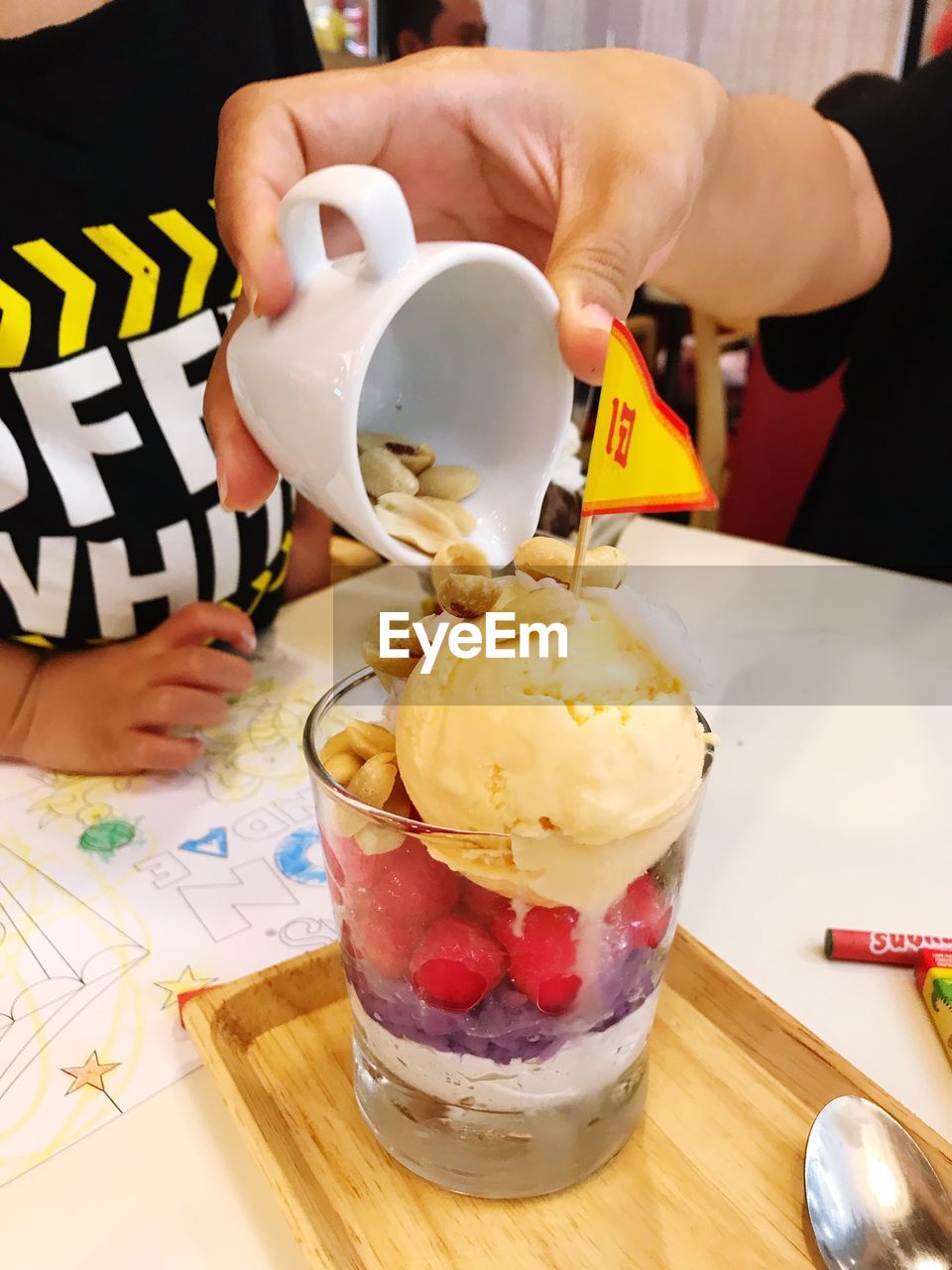 CLOSE-UP OF HAND HOLDING ICE CREAM WITH JUICE