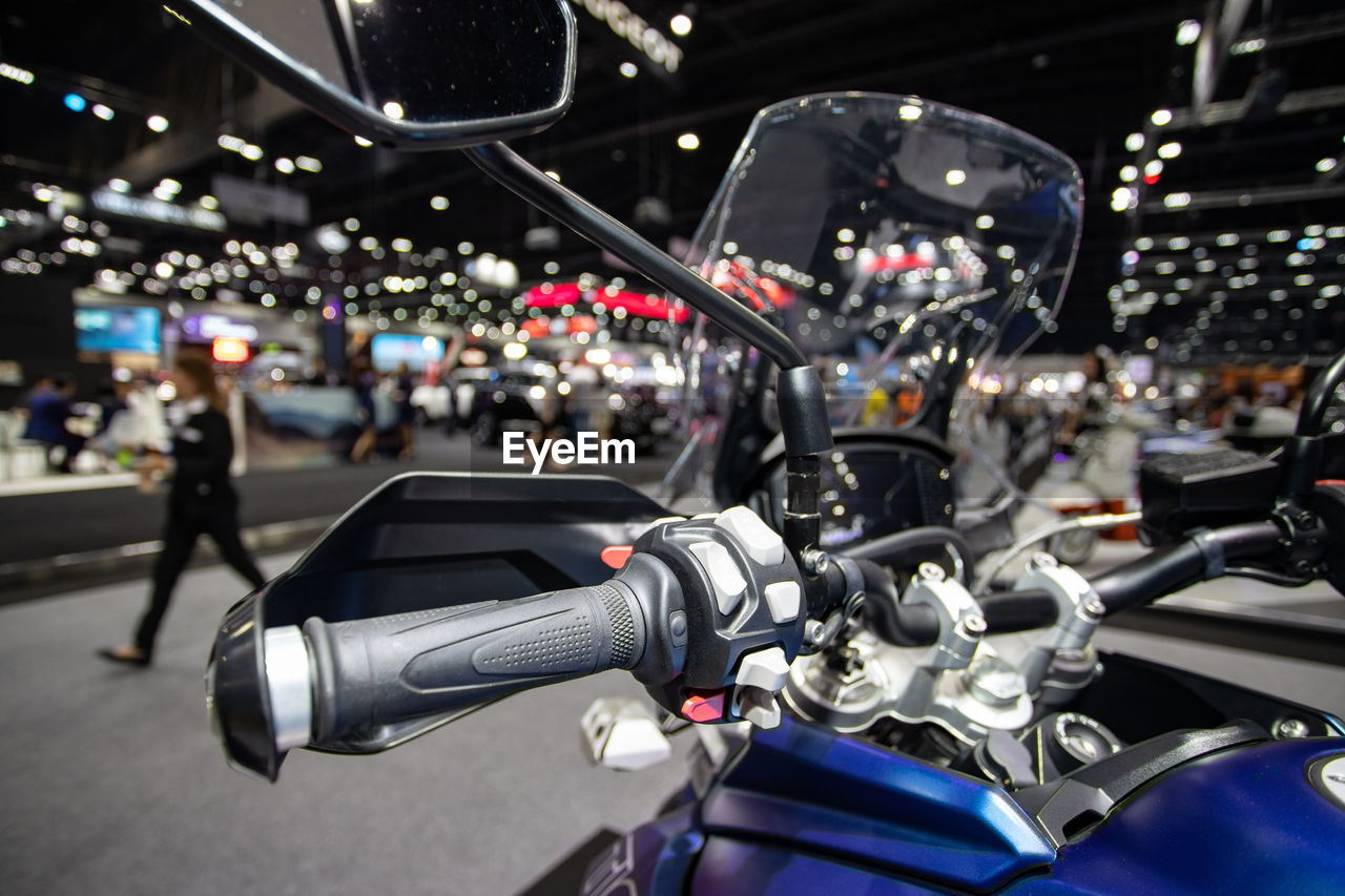 CLOSE-UP OF MOTORCYCLE ON ILLUMINATED STREET