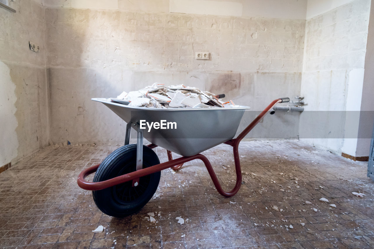 ABANDONED SHOPPING CART ON FLOOR AGAINST WALL