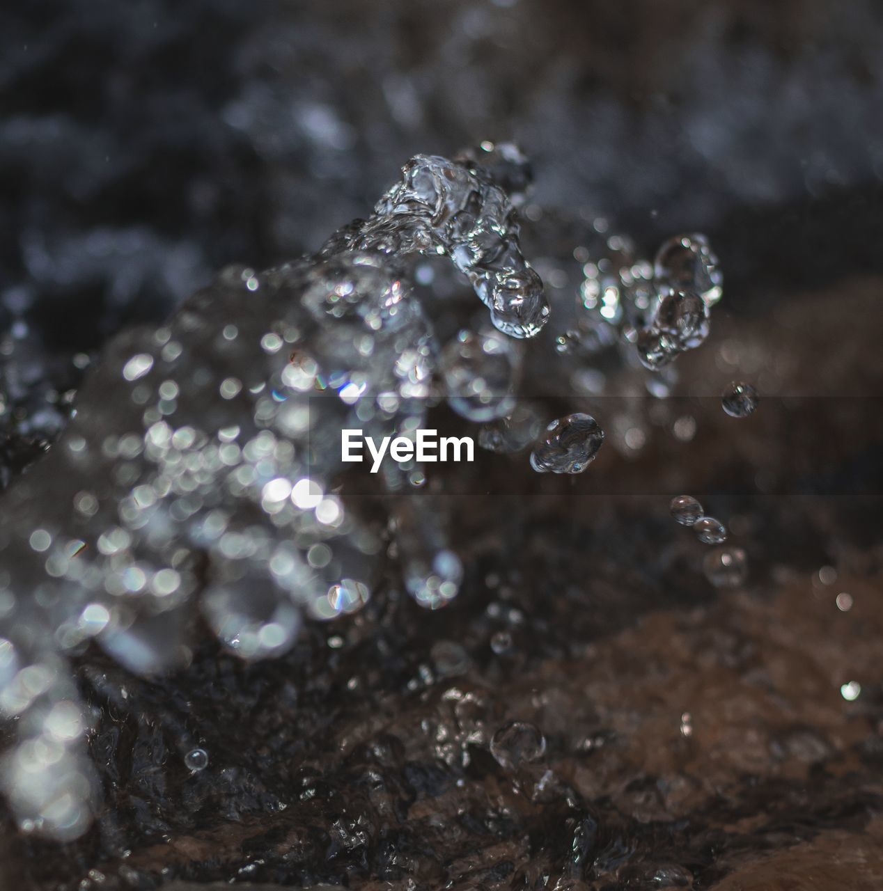 Close-up of water drops spewing over a rock