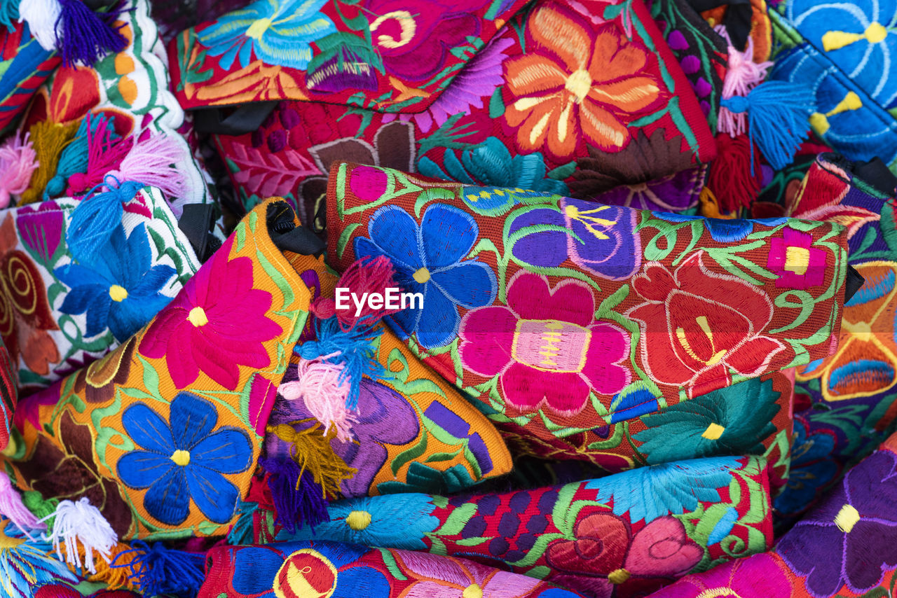Close up of traditional mexican handmade women's handbags, multicolored floral design.