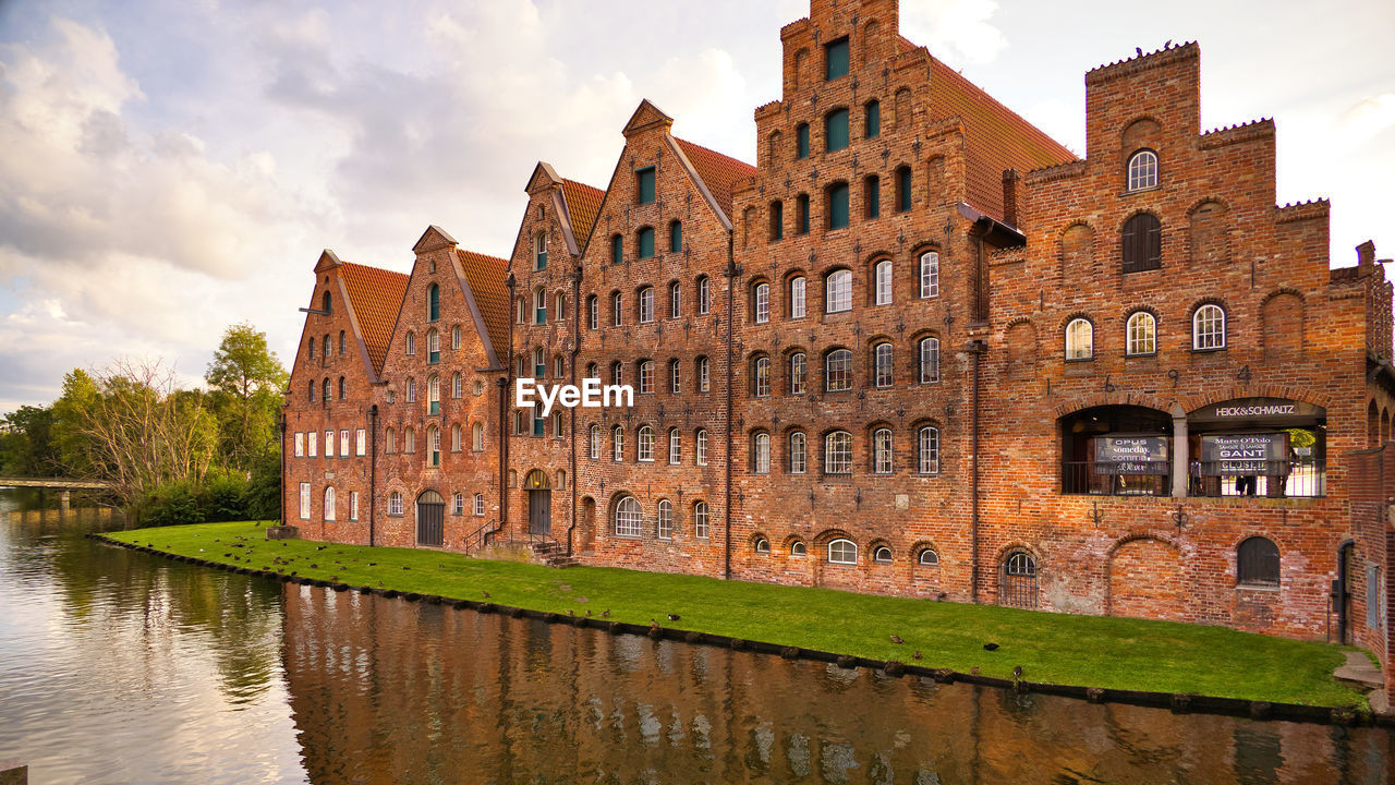 Canal by building against sky