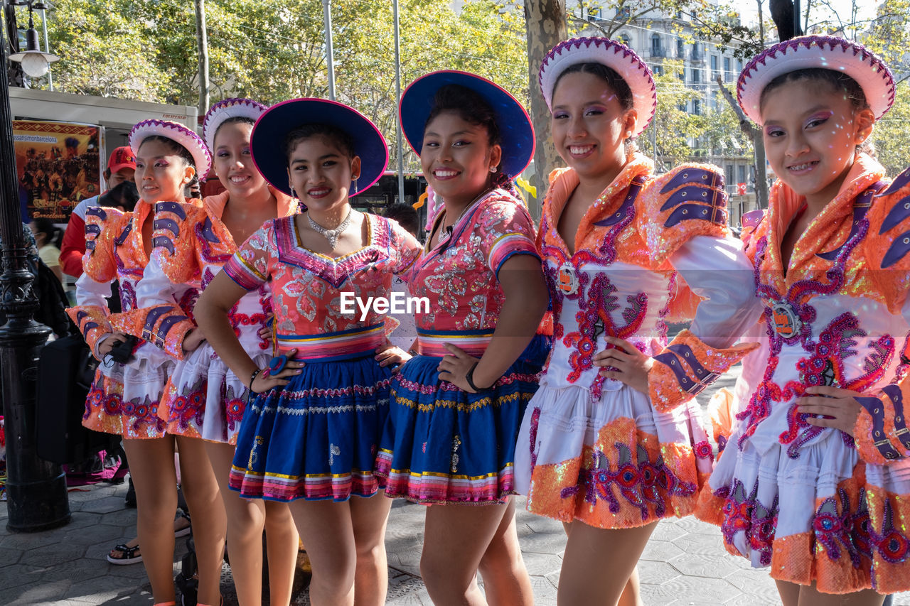 group of people, clothing, women, child, traditional clothing, childhood, tradition, festival, female, arts culture and entertainment, performance, celebration, togetherness, costume, day, dancing, portrait, smiling, sports, group, happiness, friendship, looking at camera, person, outdoors, medium group of people, headwear, standing, dress, fashion, men, hat, in a row, event, front view