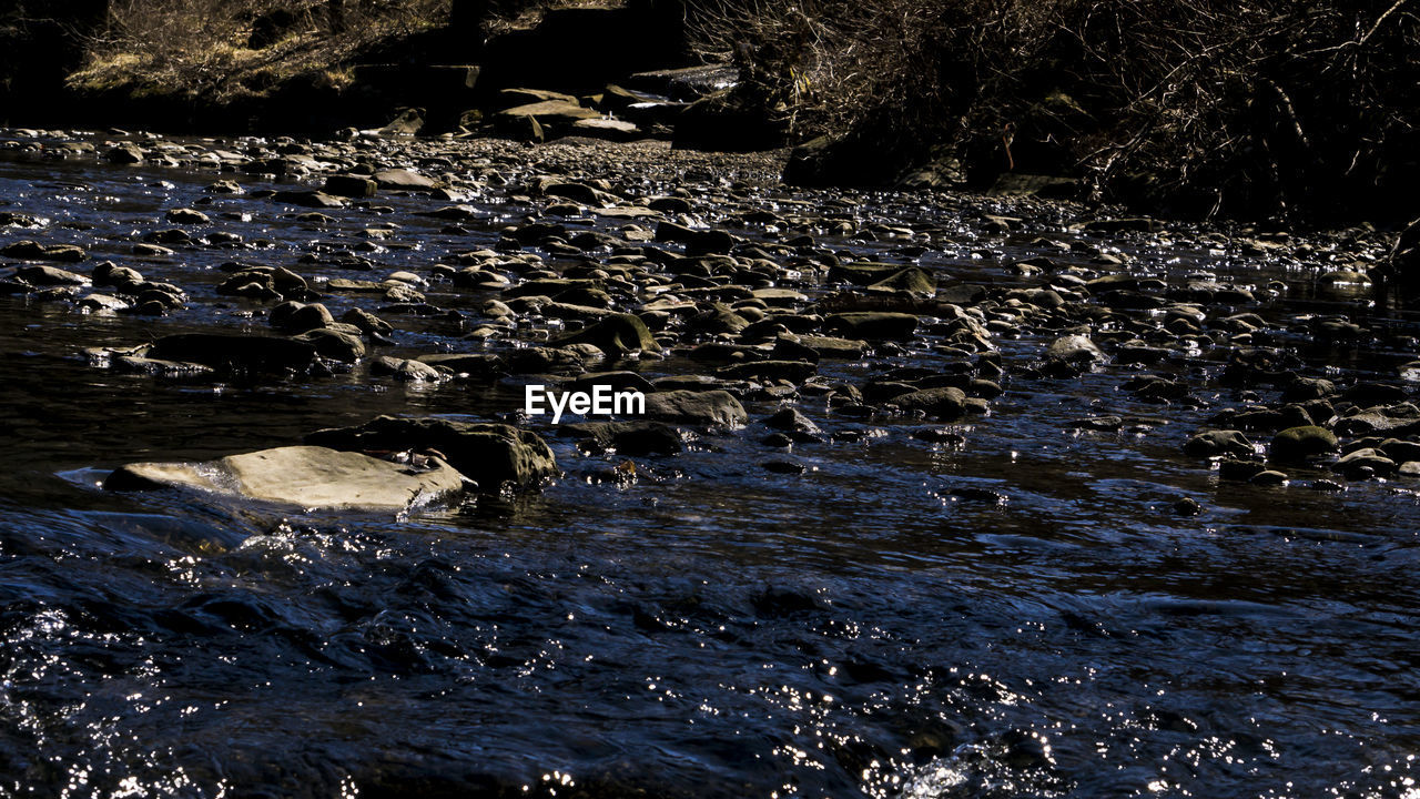 SCENIC VIEW OF RIVER FLOWING THROUGH ROCKS