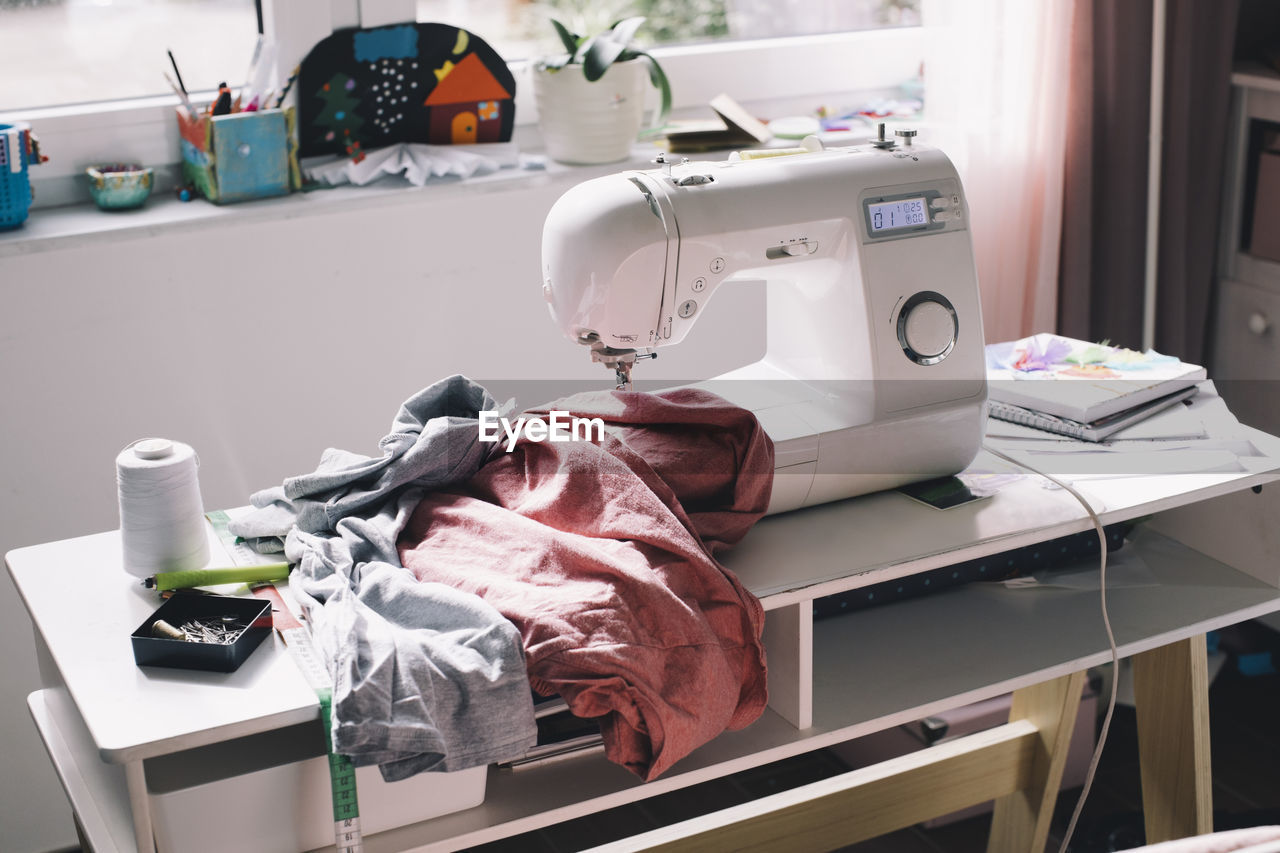 Sewing machine with clothes on table