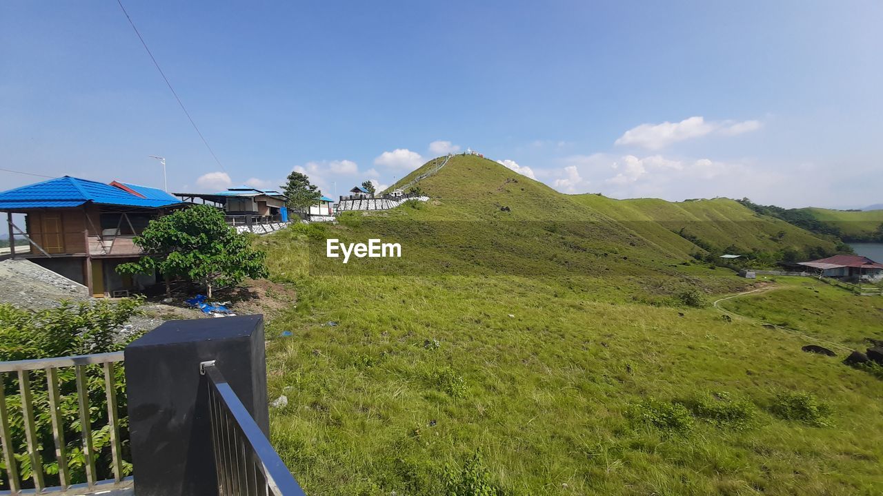 architecture, sky, built structure, building, landscape, nature, building exterior, environment, plant, house, mountain, land, grass, mountain range, scenics - nature, rural area, beauty in nature, blue, residential district, travel, green, no people, travel destinations, rural scene, village, day, cloud, outdoors, vacation, tourism, tranquility, field, water, non-urban scene, trip, holiday, summer, transportation, tranquil scene, environmental conservation