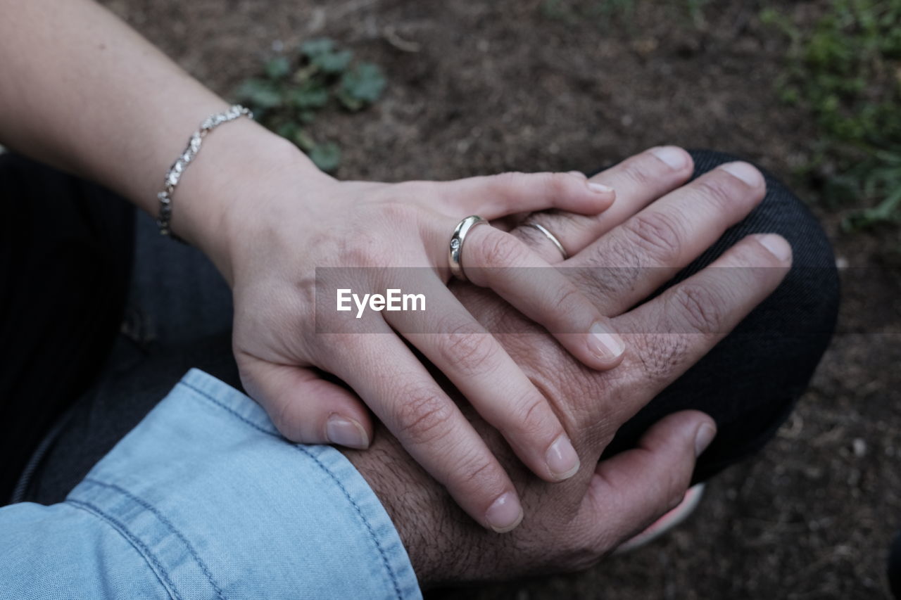 Close-up of wife holding husband hand