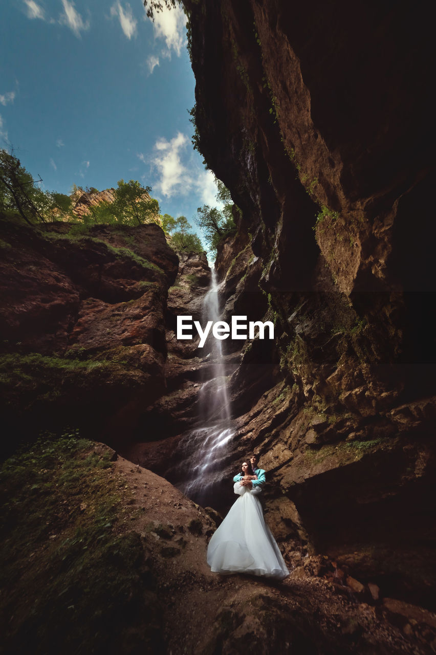 Couple in love on a waterfall. honeymoon trip. happy couple in the mountains, high angle view of the