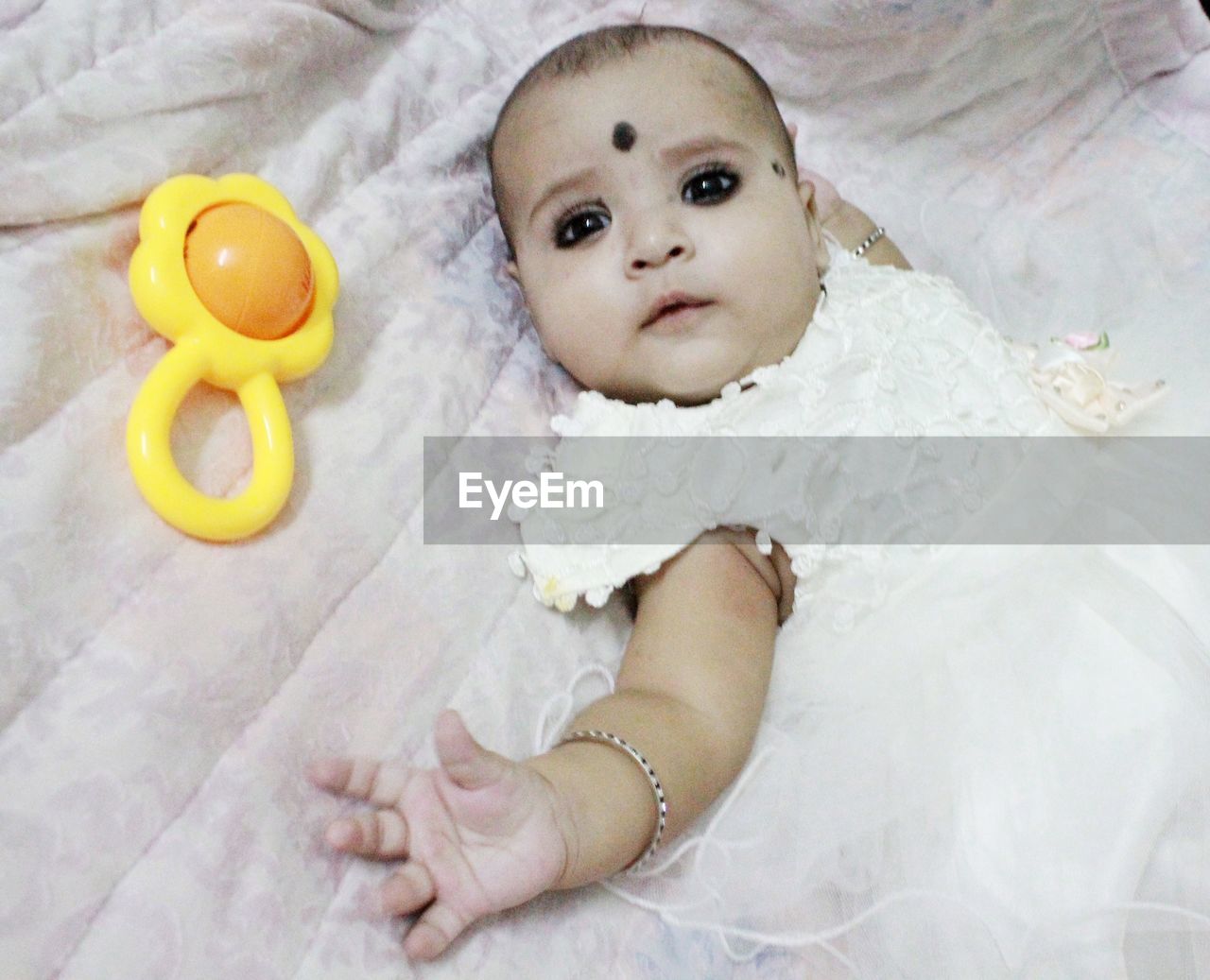 HIGH ANGLE VIEW OF BABY LYING DOWN ON BED