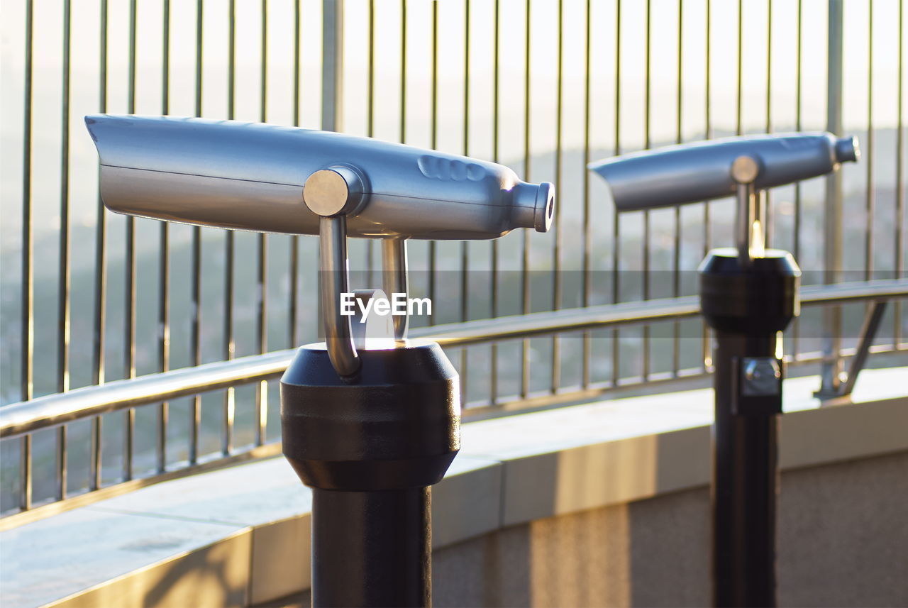 CLOSE-UP OF CAMERA ON RAILING AGAINST WALL
