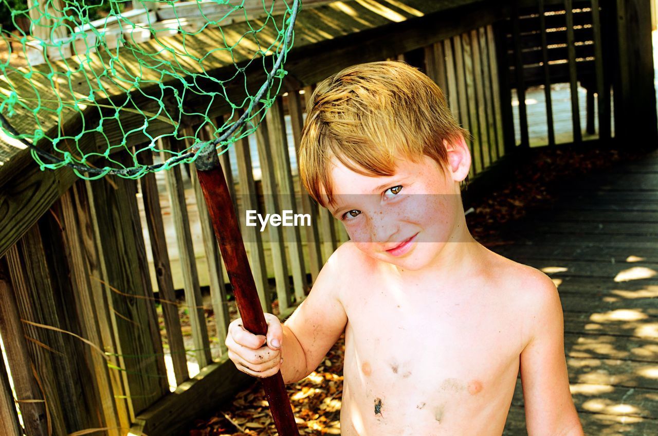 Boy holding butterfly net on boardwalk