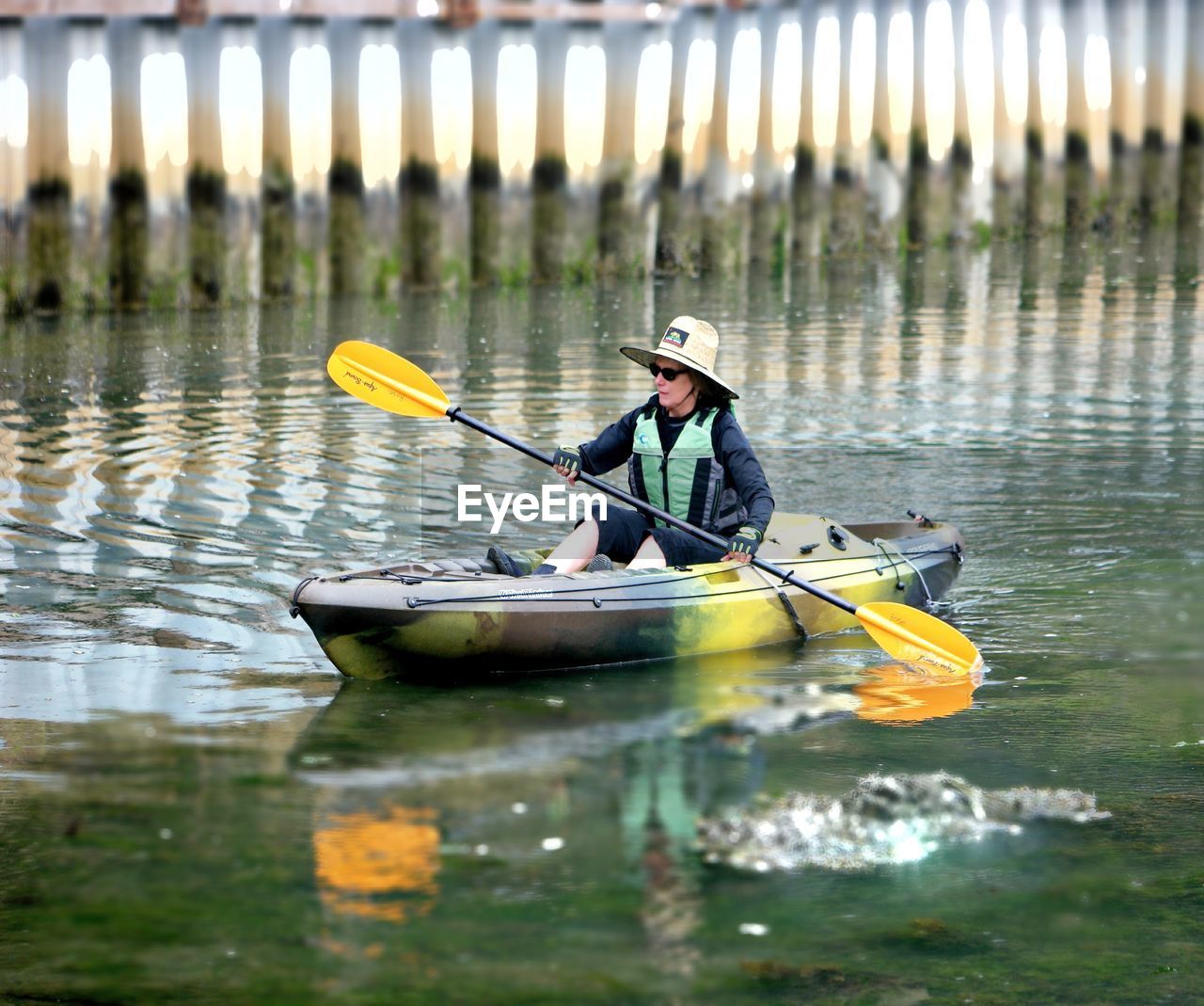 MAN SITTING IN BOAT ON LAKE