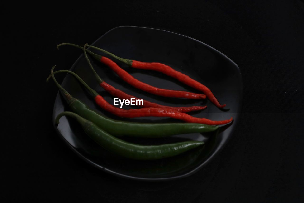 HIGH ANGLE VIEW OF RED CHILI PEPPERS ON BLACK BACKGROUND