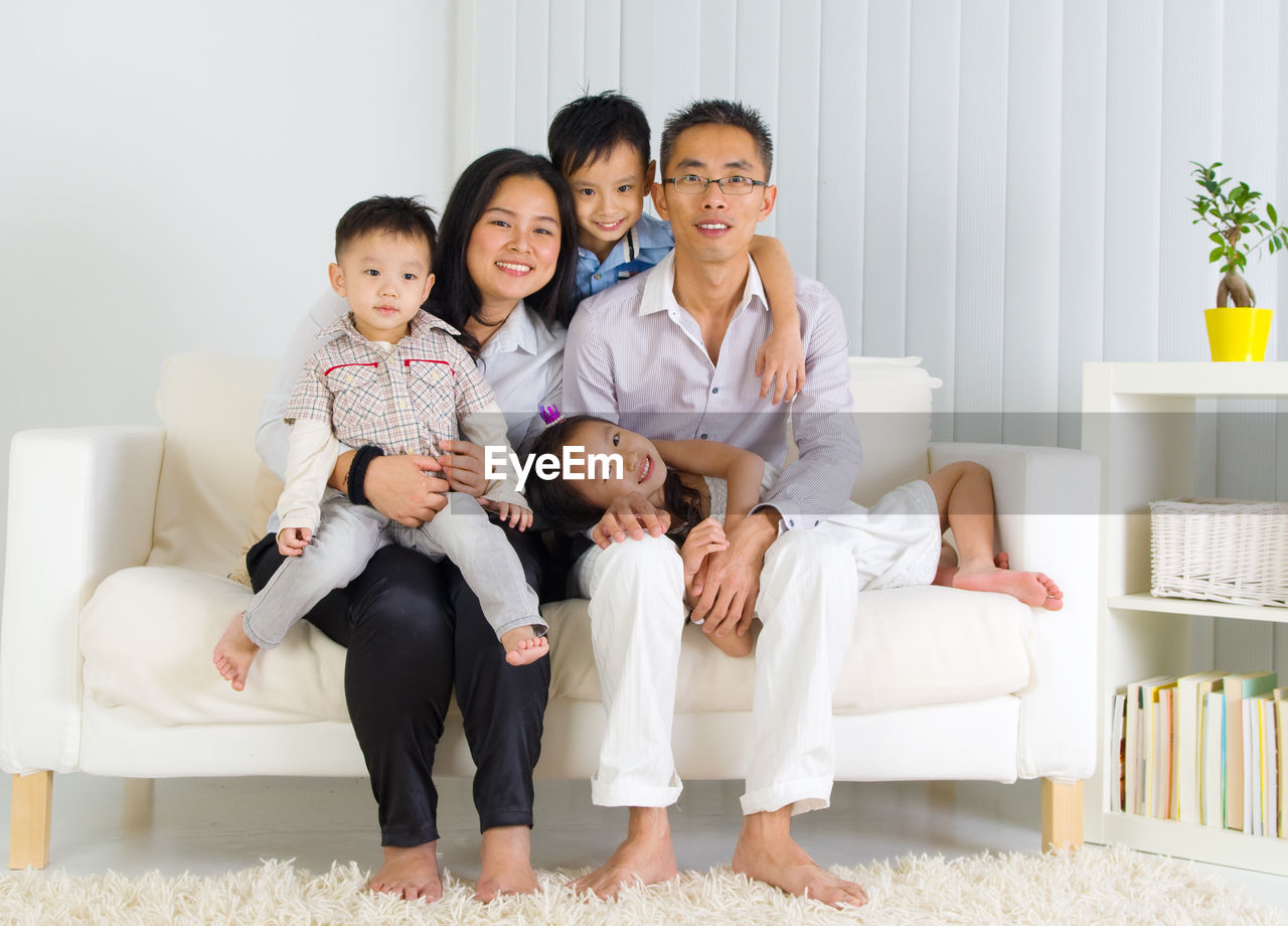 Portrait of happy family sitting on sofa at home