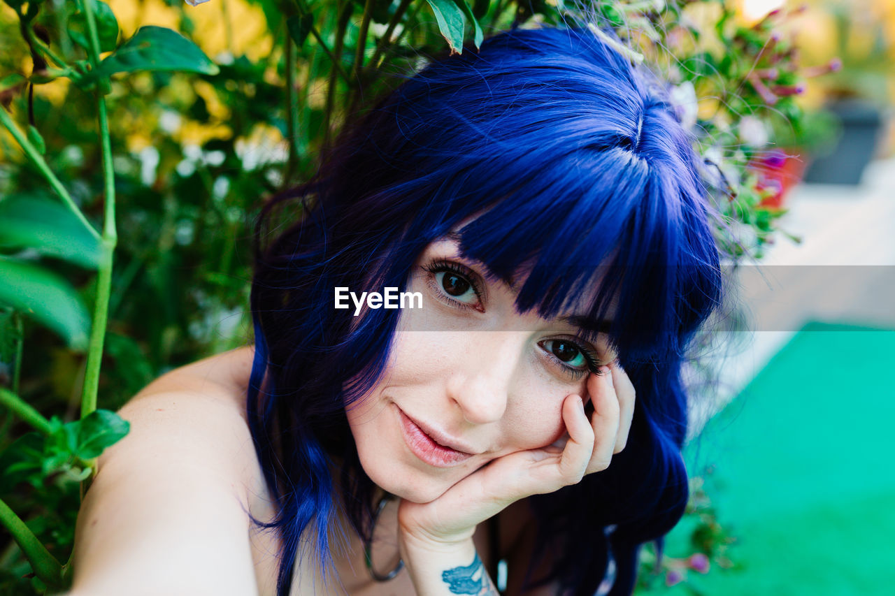 Photo of adorable young woman making selfie outdoors backyard