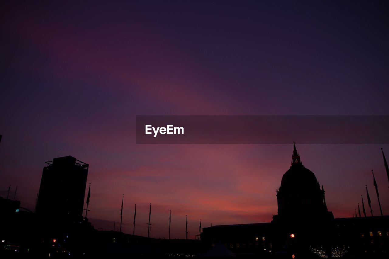 SILHOUETTE OF BUILDINGS AGAINST CLOUDY SKY