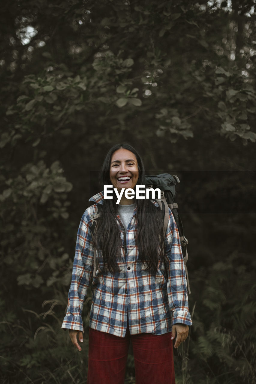 Portrait of smiling woman standing in forest