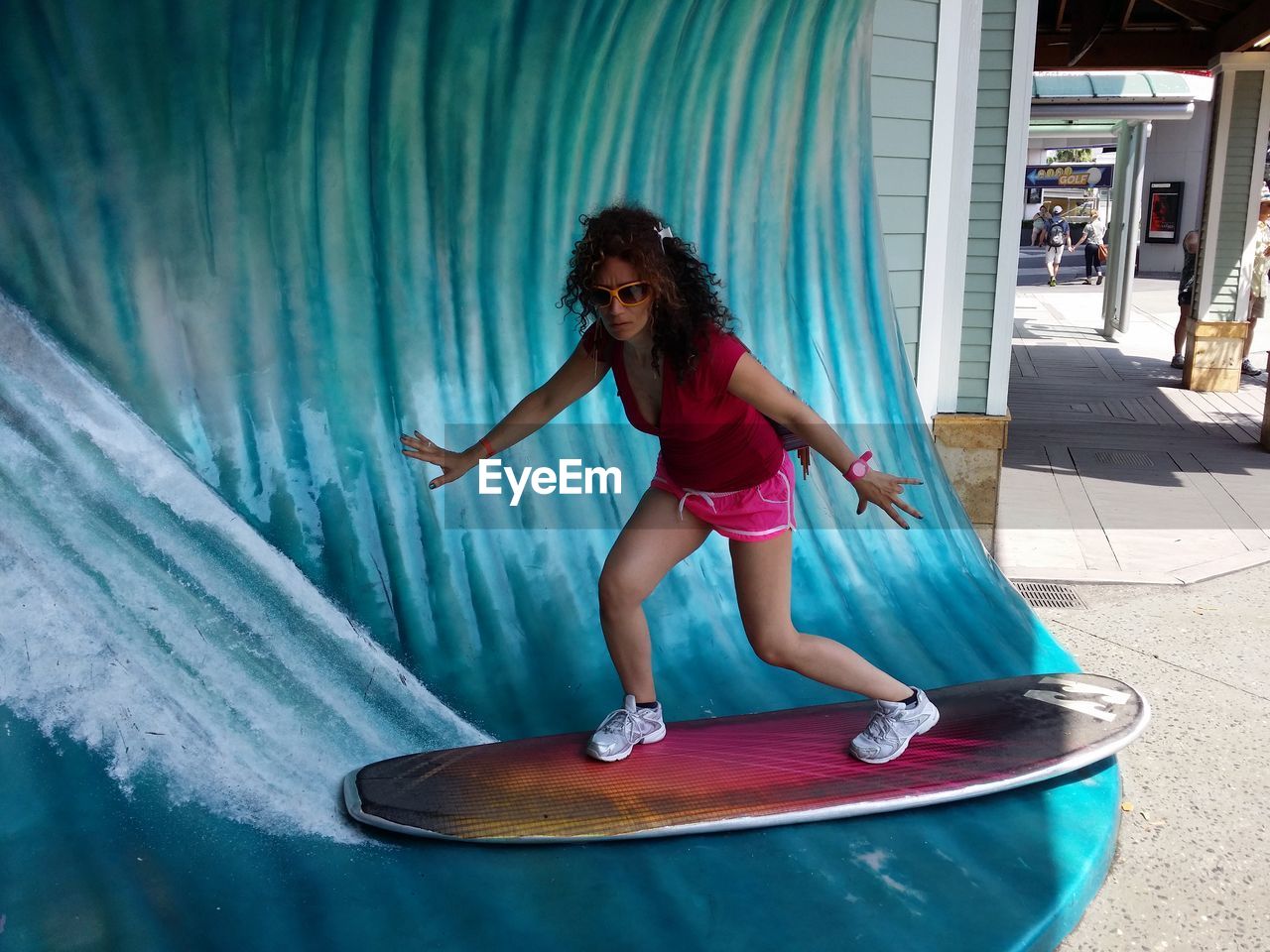 Optical illusion of woman with arms outstretched surfboarding