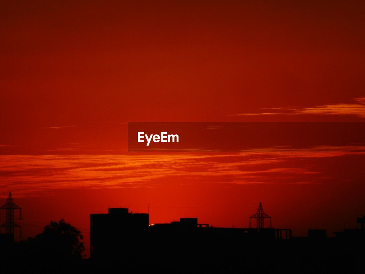 Silhouette buildings in city against sky during red sunset