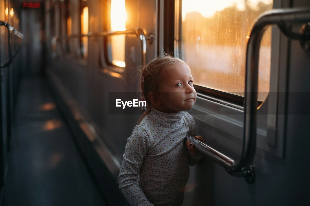 rear view of boy looking through window